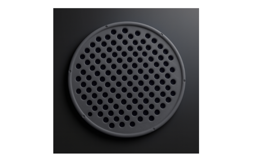 Black perforated round object on a dark background