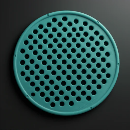 Teal circular object with holes on a black background