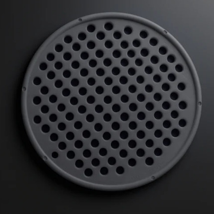 Round perforated metal cover on a dark background