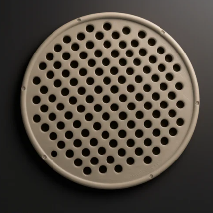 Round perforated metal filter on a dark background