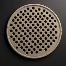 Round perforated metal filter on a dark background