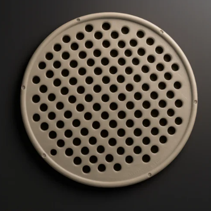 Round perforated metal filter on a dark background