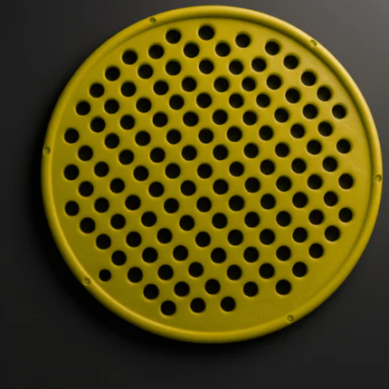 Round yellow object with holes on a black background